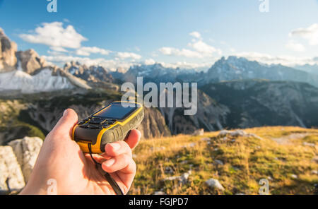 Il navigatore GPS in mano contro Dolomiti Alpi Foto Stock