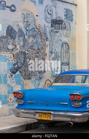 Vecchio Blu automobile Pontiac a Cuba di fronte di murales sulla parete a l'Avana, Cuba, West Indies, dei Caraibi e America centrale Foto Stock