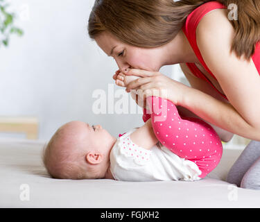 Mom gioiosa giocando con il suo bambino neonato Foto Stock