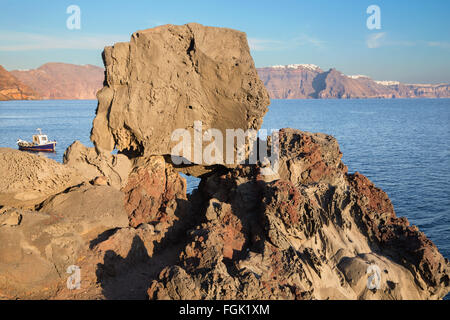 Santorini - il look di caldera tra i massi di pietra pomice con la Scaros Imerovigili ans in background. Foto Stock
