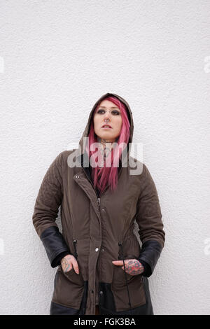 Donna con capelli rosa piercing e tatuaggio Foto Stock