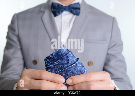 Uomo in abito grigio, plaid texture, blue bowtie e pocket Square, vicino su sfondo bianco Foto Stock