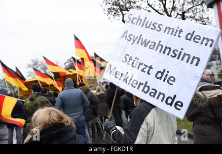 Mainz, Germania. Xx Febbraio 2016. I sostenitori del "Karlsruhe wehrt sich' (Karlsruhe resist), una propaggine regionale dell'anti-islamico e movimento xenofobo Pegia, portano un cartello che recita di lit. 'Stop l'asilo crazyness - rovesciare la Merkel pista' durante un rally in Mainz, Germania, 20 febbraio 2016. Il rally detenute da "Karlsruhe wehrt sich' è una propaggine regionale dell'anti-islamico e xenofobi Pegia movimento e sta protestando contro la pubblica Emittente Suedwestrundfunk (CFA). Foto: Arne Dedert/dpa/Alamy Live News Foto Stock