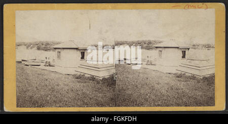 Fotografia di T. C. Roche che mostra una casa temporanea su un lago ai piedi di una terrazza. L'immagine cattura la struttura nel suo ambiente lacustre. Foto Stock
