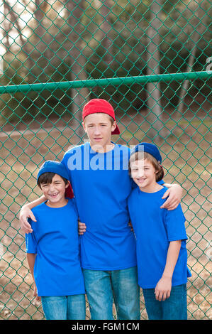 Outdoor ritratto di gruppo di tre ragazzi che sono amici in posa dopo la riproduzione di backyard baseball. Foto Stock