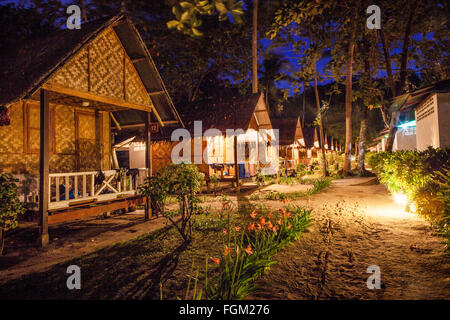 Una fila di holiday bungalow sulla spiaggia in Thailandia di notte Foto Stock