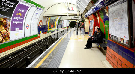 In attesa di un treno a Piccadilly stazione della metropolitana di Londra Foto Stock