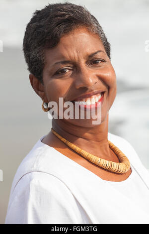 Felice senior americano africano donna sorridente su una spiaggia Foto Stock
