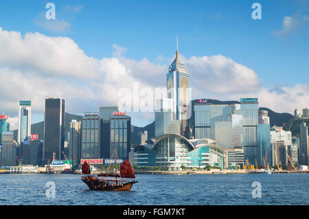 Immondizia barca passando Convention Center e Dell'Isola di Hong Kong skyline di Hong Kong, Cina Foto Stock