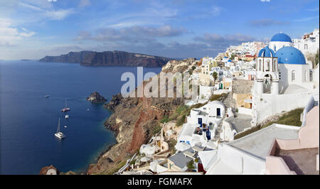 Santorini - il look di tipicamente blu cupole della chiesa di Oia sulla caldera e il Therasia isola in background. Foto Stock