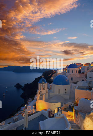 Santorini - il look di tipicamente blu cupole della chiesa di Oia sulla caldera e il Therasia isola. Foto Stock