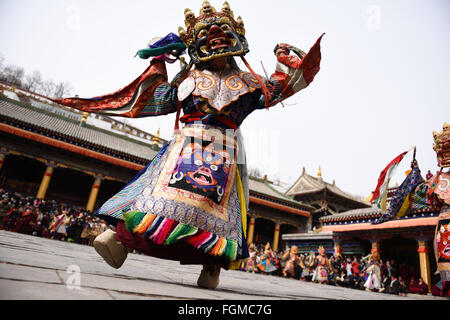 Xining, la Cina della Provincia di Qinghai. Il 21 febbraio, 2016. Un monaco esegue 'Tiaoqian', una mascherata danza religiosa con una storia di quasi 300 anni, presso il monastero di Kumbum in Huangzhong County, a nord-ovest della Cina di Provincia di Qinghai, Feb 21, 2016. Durante il rito religioso, i monaci si usura colorati abiti tradizionali e maschere, esecuzione di danza per spaventare gli spiriti malvagi. Credito: Wu pista/Xinhua/Alamy Live News Foto Stock