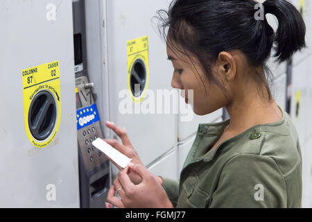 Donna preme i pulsanti sull'armadietto di sicurezza Foto Stock