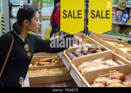 Donna pasticceria shopping al supermercato Foto Stock