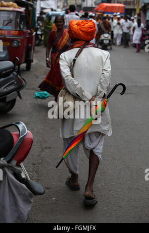 Pune, India - 11 Luglio 2015: un vecchio warkari a piedi giù per la strada durante il famoso festival di Wari in India. Foto Stock