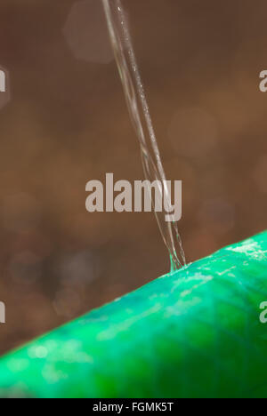 Molleggiante che perde una perdita della tubazione flessibile di getto di acqua di streaming a perdita di pressione tubo flessibile da giardino Foto Stock