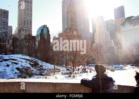 Bambino guardando il cielo raschiatori e Park di New York City in inverni di neve Foto Stock