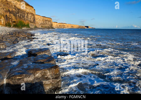 Guardando verso est da St Donats, Vale of Glamorgan ad alta marea, poco prima del tramonto Foto Stock