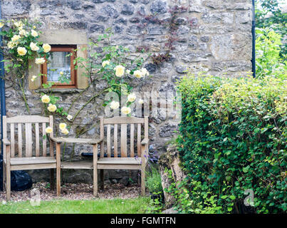 Tavoli e sedie in legno al di fuori del vecchio cottage in pietra, Carlton, North Yorkshire, Inghilterra Foto Stock