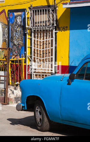 Vecchio Blu auto parcheggiate in strada con artwork dipinta su edifici al Callejon de Hamel, Havana, Cuba, West Indies, dei Caraibi e America centrale Foto Stock