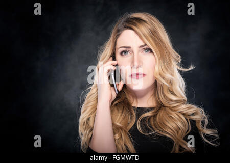 Donna che chiama con un telefono cellulare. Foto Stock