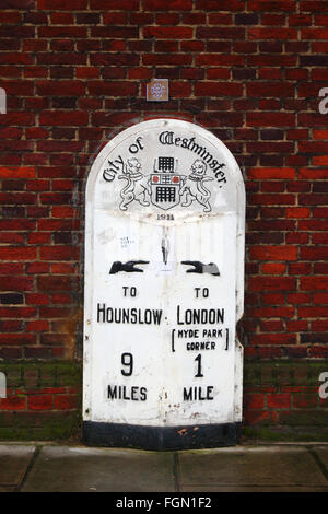 Old Mile post datato 1911 con una versione dello stemma originale della City of Westminster con un portcullis, Kensington High Street, Londra, Inghilterra Foto Stock