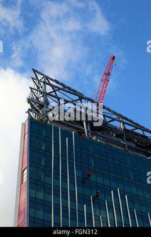 Lavoratori di vetro sulla facciata di edificio sul cerchio di Victoria sito in costruzione, Victoria, London, England Regno Unito Foto Stock