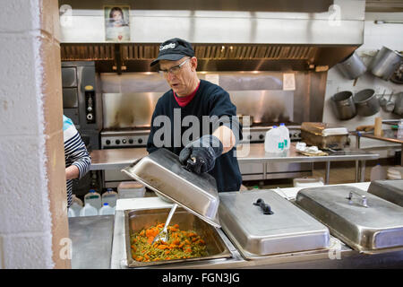 Selce, Michigan - un volontario aiuta a servire un pasto presso il North End Soup Kitchen, che viene azionato dal Catholic Charities. Foto Stock