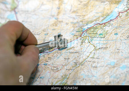 Mappa strumento di misurazione chiamato curivmeter o curvimetro. Ruota su un mandrino filettato. Utilizzato per misurare le distanze sulla mappa. Foto Stock