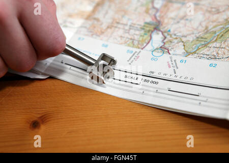 Mappa strumento di misurazione chiamato curivmeter o curvimetro. Ruota su un mandrino filettato. Utilizzato per misurare le distanze sulla mappa. Foto Stock