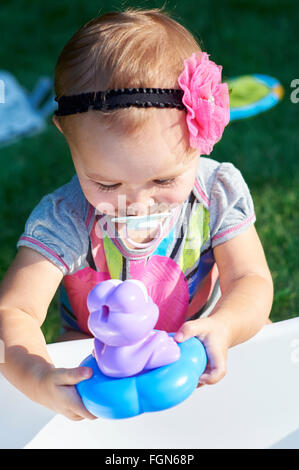 Carino bambina gioca con i giocattoli Foto Stock