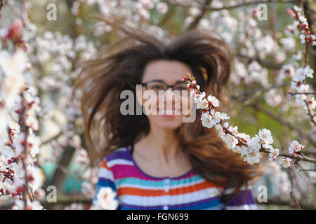 Ritratto di sorridere caucasian brunette donna nella primavera blossom garden Foto Stock