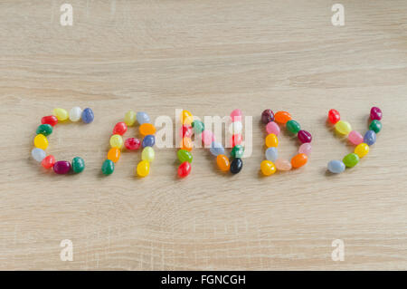 Parola candy da Jelly Beans su sfondo di legno Foto Stock