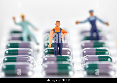 Miniatura uomini di lavoro permanente sulla confezione di pillole di medico Foto Stock