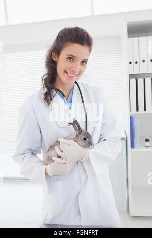 Vet sorridente con un coniglio nelle sue braccia Foto Stock