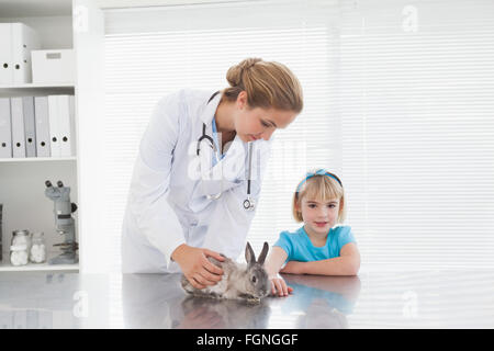 Vet mostra una giovane ragazza un coniglietto coniglio Foto Stock