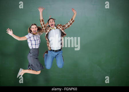 Immagine composita di geeky hipsters jumping e sorridente Foto Stock