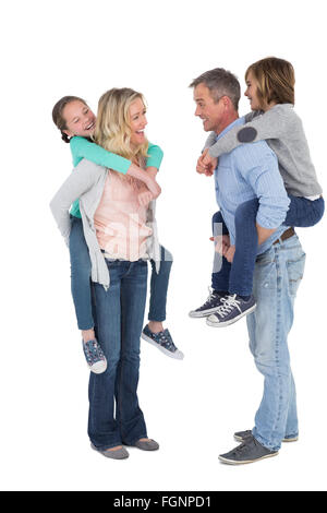 Felice di due genitori di dare ai loro bambini un piggy back Foto Stock