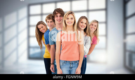 Immagine composita di piena lunghezza shot di un gruppo sorridente in piedi dietro un altro a vari angoli Foto Stock