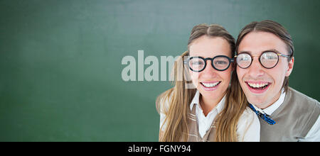 Immagine composita di geeky hipsters sorridente in telecamera Foto Stock