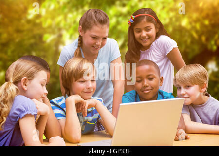 Immagine composita di graziosi gli studenti usando computer tablet in libreria Foto Stock