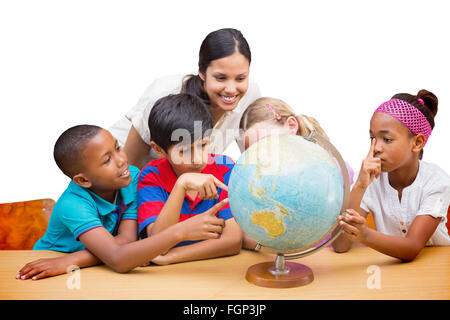 Immagine composita di graziosi gli alunni e gli insegnanti guardando il globo in biblioteca Foto Stock