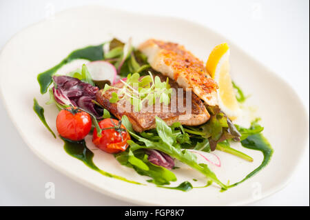 Stile moderno e pulito e il cibo, salmone alla griglia con toast e insalata condita con salsa verde Foto Stock