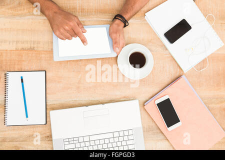 Mani con tablet accanto a dispositivi diversi Foto Stock