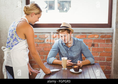 Cameriera bionda che mostra bill al bello hipster Foto Stock