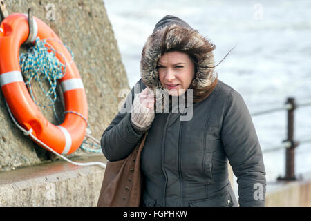 New Brighton Promenade, Wallasey, Regno Unito. 22 feb 2016. Regno Unito: Vento continuano a pastella nord ovest Inghilterra. Questi dog walkers sono irrigati dall'alta marea violare su New Brighton Sea difese. Credito: Cernan Elias/Alamy Live News Foto Stock