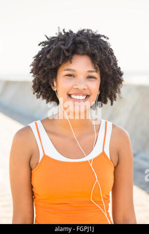 Giovane donna sportivo godendo la musica attraverso le cuffie Foto Stock