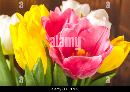 Bouquet di tulipani nella parte anteriore della molla scena sullo sfondo di legno. un mazzo di fiori per il 8 marzo o il giorno di san valentino Foto Stock