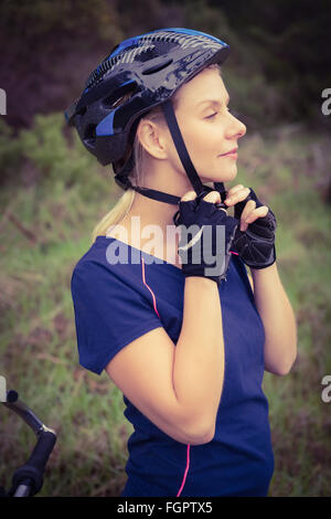 Athletic bionda mettendo sul casco Foto Stock