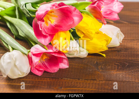 Bouquet di tulipani nella parte anteriore della molla scena sullo sfondo di legno. un mazzo di fiori per il 8 marzo o il giorno di san valentino Foto Stock